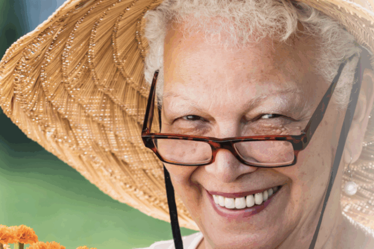 Senior woman with glasses and hat holding marigold plans