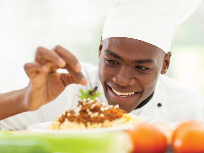 Chef Chef garnishing a plate of red beans and rice